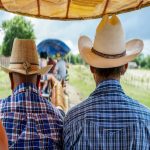 two man with western shirts and cowboy hats