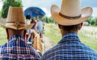 two man with western shirts and cowboy hats