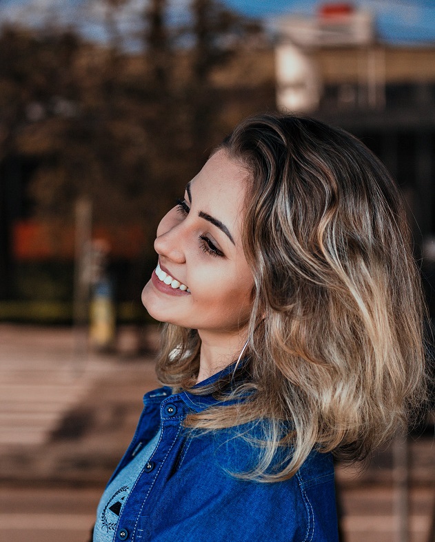 picture of woman smiling with casual outfit and a natural hair style