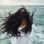 picture of a woman in front a ocean waving her hair