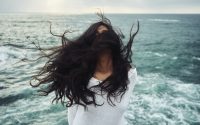 picture of a woman in front a ocean waving her hair