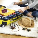 Woman preparing the suitcase at home for travelling