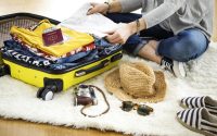 Woman preparing the suitcase at home for travelling