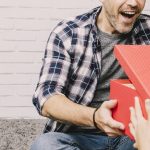 man opening a gift box with beer