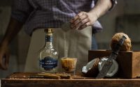 Bartender preparing a cocktail with Don Roberto 1924 tequila and fresh coconut.